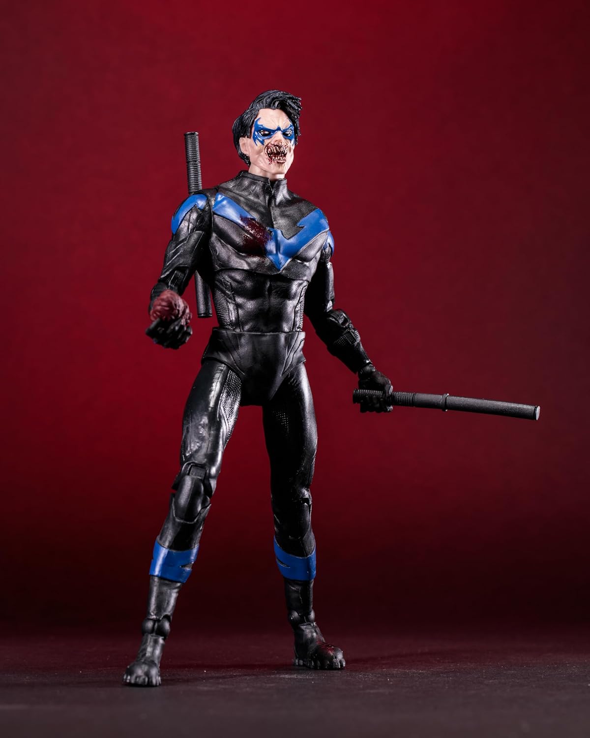 Nightwing vampiro visto desde arriba, con las manos ensangrentadas